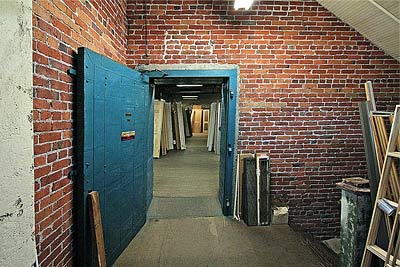A Photo of a doorway in a brick wall, with an open fire door.